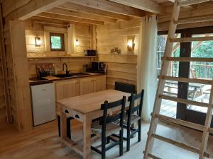 a kitchen with a wooden table and a ladder at Le Jardin Des Cabanes in Gilly-sur-Loire