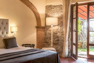 a bedroom with a bed and a stone wall at Calidario Terme Etrusche in Venturina Terme