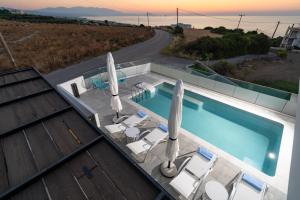 una piscina con sillas y sombrillas en una casa en 4C Rethymno, en Skaleta