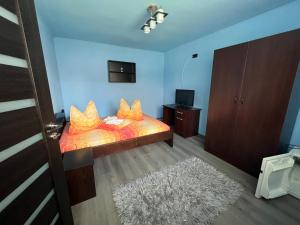 a bedroom with a bed with orange pillows on it at Casa Tofalvi in Sovata