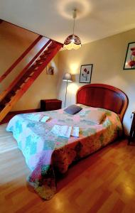 a bedroom with a bed in a room with a staircase at L'AUBERGE DE LA PORTE in Saint-Jouan-des-Guérets