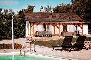 a gazebo with two chairs next to a swimming pool at Holiday House Sunset Spa in Šentjernej