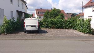 une camionnette blanche garée sur le côté d'une rue dans l'établissement Monteur - Ferienwohnung Marburg - Biedenkopf - Steffenberg - mit 4 Zimmer und Balkon, à Obereisenhausen