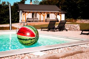 une pastèque dans une piscine avec un ballon à l'eau dans l'établissement Holiday House Sunset Spa, à Šentjernej