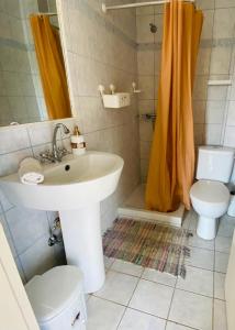 a bathroom with a sink and a toilet and a shower at ISLAND HOUSE in Poros
