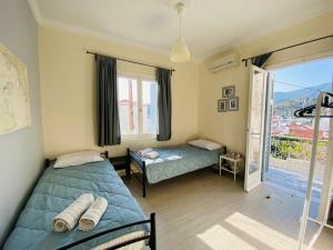 sypialnia z 2 łóżkami i dużym oknem w obiekcie ISLAND HOUSE w Poros