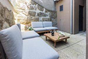 two chairs and a coffee table on a patio at Guest H4U - Porto Bonfim Heroismo in Porto