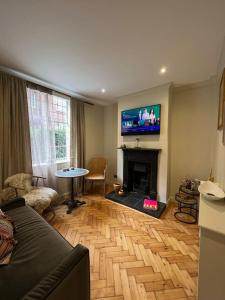 a living room with a fireplace and a tv at Luxury London English Charm in London