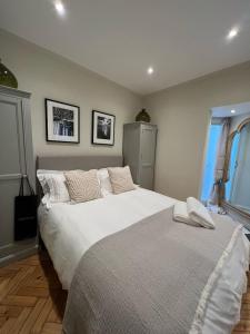 a bedroom with a large white bed and two windows at Luxury London English Charm in London
