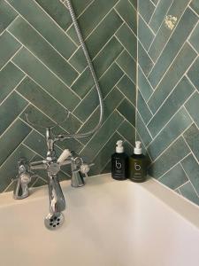 a bathroom sink with two bottles of soap on it at Luxury London English Charm in London