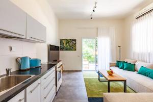 a kitchen and living room with a couch and a table at Designed 2BR apartment over Dizengoff square - Panoramic View in Tel Aviv