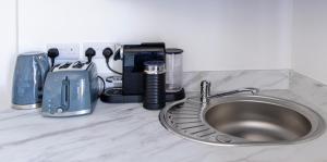 a kitchen counter top with a sink and appliances at Causeway Coast Retreats 