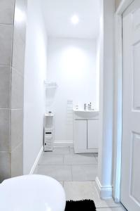 bagno bianco con doccia e lavandino di City Central Apartments a Londra