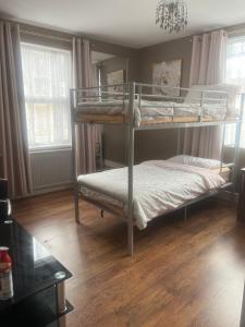 a bedroom with two bunk beds and a table at Medway Stay in Chatham