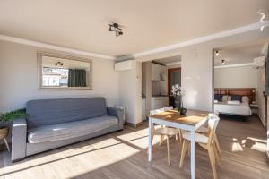 ein Wohnzimmer mit einem Sofa und einem Tisch in der Unterkunft Apartamentos Alhambra Granada 3000 in Granada