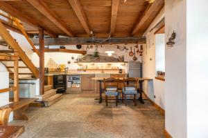a kitchen with wooden ceilings and a table and chairs at Casa Carincio, Falesina Ospitar in Vignola