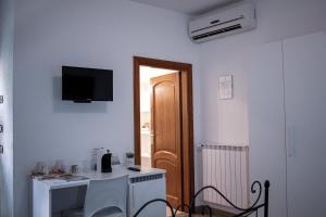 a room with a desk and a television on the wall at Mare Sole in San Teodoro