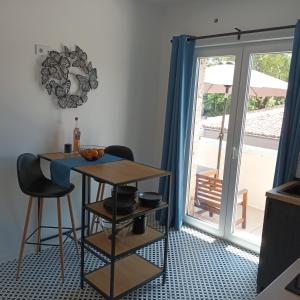a table and chairs in a room with a sliding glass door at Holiday Apartment ORA in Balchik