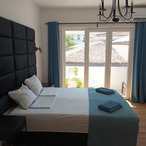 a bedroom with a bed with a large window at Holiday Apartment ORA in Balchik