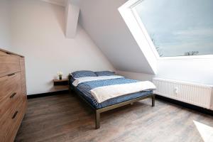 een slaapkamer met een bed en een groot raam bij VIP ApB 63qm 3 Zi Dachgeschoss Klimaanlage große Wohnküche großes Bad 2 WCs 3 Betten 1 Schlafsofa in Schwedt