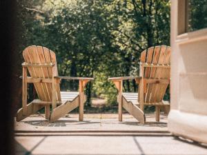 twee houten stoelen naast elkaar op een veranda bij de Wever Lodge in Otterlo