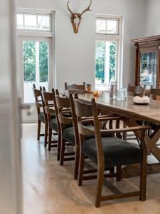 een eetkamer met een houten tafel en stoelen bij de Wever Lodge in Otterlo