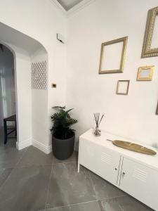 a white room with a table and a plant on a wall at Anema e Core in Naples +2 photos