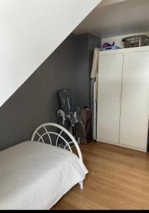 a bedroom with a white bed and a white cabinet at Appartement 6/8 pers Le Petit Bertin in La Bresse