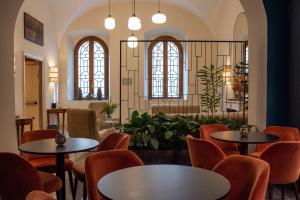 una sala de espera con mesas, sillas y ventanas en Sentho Roma, en Roma