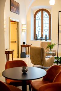 a waiting room with chairs and tables and a window at Sentho Roma in Rome