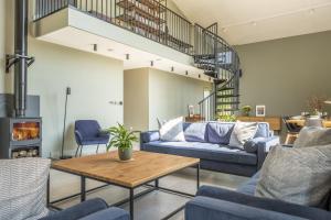 a living room with blue couches and a table at The Grain Store in Reepham