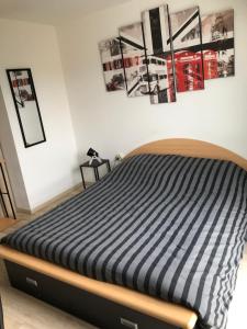 a bed in a bedroom with pictures on the wall at Chambres chez Philippe in Ludres