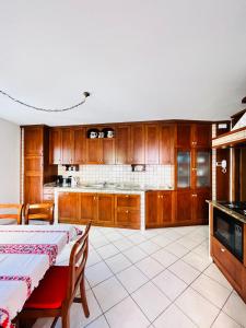 a kitchen with wooden cabinets and a table with a tablecloth at Casa Margheritina in Malcesine