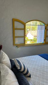 a bedroom with a bed with a large window at Hospedaria do Marquês in Boicucanga