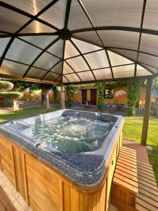 una gran bañera de hidromasaje en un patio trasero con sombrilla en Espacios Del Mundo, en Carenas