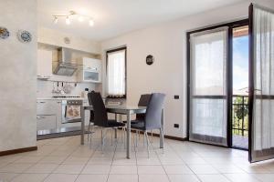 Una cocina y un comedor con mesa y sillas. en Residenza Contrada, en Cocquio Trevisago
