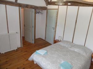 a bedroom with a bed with two blue towels on it at GersGites in Justian