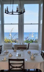 a dining room with a table with a view of the ocean at Mount Royal - Penzance in Penzance