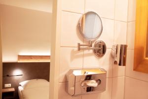 a bathroom with a mirror and a toilet at Hotel Mintarder Wasserbahnhof in Mülheim an der Ruhr