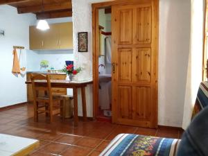 cocina y comedor con mesa y puerta en Olive tree Cottages, en Palaiochóra