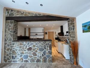 a stone wall in the kitchen of a house at Le Repère du Loup in Malbosc