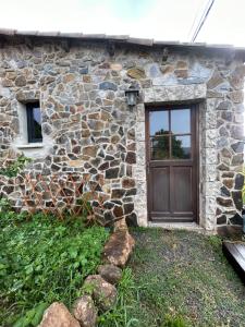 Casa de piedra con puerta de madera y ventana en Le Repère du Loup, en Malbosc