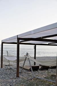 two hammocks under a canopy on a beach at Четыре Сезона in Novy Afon