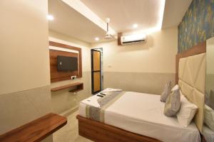 - une chambre avec un lit et une télévision murale dans l'établissement Hotel Dream Palace Residency - Near US Consulate, BKC LBS Marg, à Mumbai