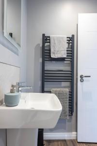 a bathroom with a white sink and a towel rack at Causeway Coast Retreats 