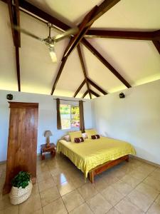 a bedroom with a bed in a room with wooden ceilings at O'coco Bungalow in Paea