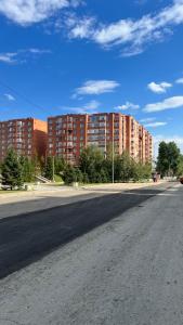 een lege straat voor een paar hoge gebouwen bij Жилой комплекс Ирина in Pavlodar +16 foto's