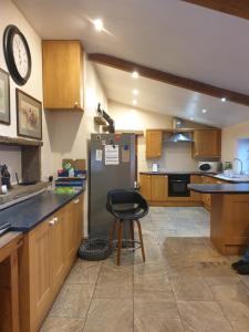 a kitchen with a refrigerator and a stool in it at The Coach House 