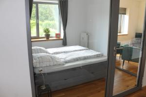 a mirror reflecting a bed in a room with a window at Ferienwohnung Haus Knäppen Size S in Oelde