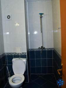 een badkamer met een toilet en een douche met blauwe tegels bij Хотел ФТР Подкрепа(Вивас) in Primorsko